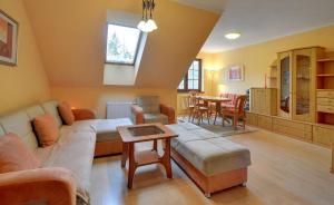 un soggiorno con un divano e un tavolo di Żółty Apartament Sun Seasons 24 w Karpaczu z Balkonem by Noclegi Renters a Karpacz