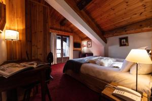 a bedroom with a bed and a desk with a telephone at La Savoyarde in Val dʼIsère