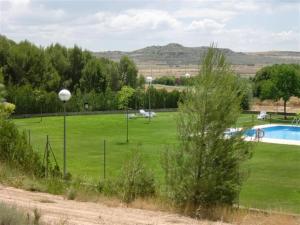 a large green field with a swimming pool at CASA JUNTO AL PARQUE NATURAL DE LAS BARDENAS in Sádaba