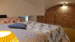 a room with two beds and a brick wall at Holiday House da Carlo in Catania