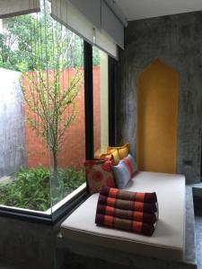 Cama en habitación con ventana grande en Mook Lamai Resort and Spa en Ko Mook