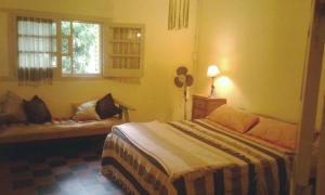 a bedroom with a bed and a window and a couch at Abbá Departamentos in Mina Clavero
