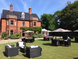 a house with chairs and tables in front of it at Blakeney House in Blakeney