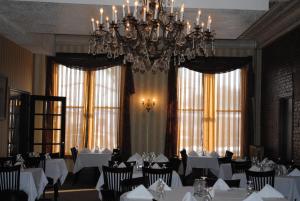 a dining room with white tables and a chandelier at Hotel Wayne in Honesdale