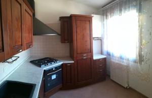 a kitchen with wooden cabinets and a stove at B&B Traghetto in Porto Garibaldi