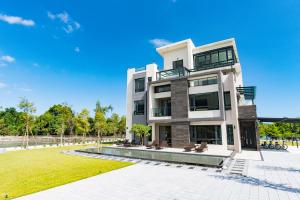 a large building with a lawn in front of it at Follow the Cloud B&B in Jialin