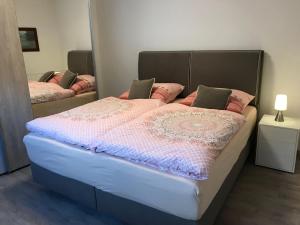 a large bed in a room with a mirror at Haus-Hafenblick in Lassan