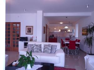 a living room with a white couch and a kitchen at Villa del Mar in Herceg-Novi