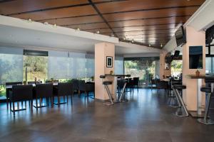 a dining room with tables and chairs and windows at Kavos Plaza Hotel in Kavos