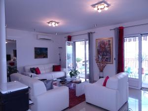 a living room with white furniture and a balcony at Villa del Mar in Herceg-Novi