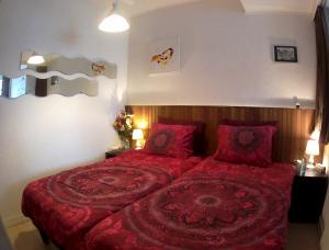 a bedroom with a large red bed with red pillows at Imagine My B&B in Rotterdam