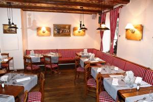 un ristorante con tavoli e sedie in una stanza di The Originals Boutique, Hôtel La Ferme du Pape, Eguisheim a Eguisheim