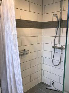 a bathroom with a shower with white tiles at Haus-Hafenblick in Lassan