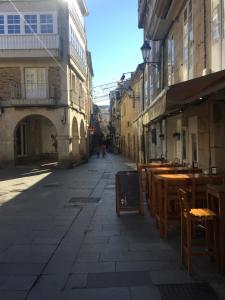 una calle vacía con mesas y sillas en un callejón en Casa del Columpio en PLENO centro de Lugo en Lugo