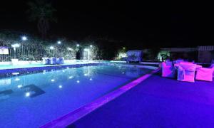 ein Pool in der Nacht mit violetten Lichtern in der Unterkunft HOTEL ZIDANE in Sétif