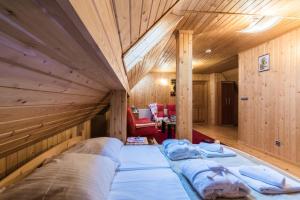 a large bed in a room with wooden walls at Rezydencja Marjo z basenem in Kościelisko +45 photos