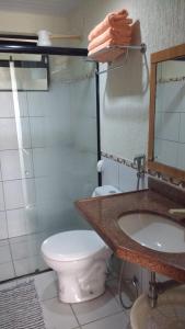 une salle de bains avec toilettes, lavabo et miroir dans l'établissement FLAT VILA DO MAR, à Aquiraz