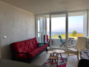 a living room with a red couch and a view of the ocean at Costa Quilén - Vista al Mar Dpto 241 in Puchuncaví