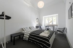 Schlafzimmer mit einem schwarzen und weißen Bett und einem Fenster in der Unterkunft Saldanha Prestige in Lissabon