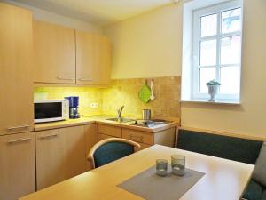 a small kitchen with a table and a microwave at Ferienwohnung, Weingut Trockene Schmitts in Randersacker