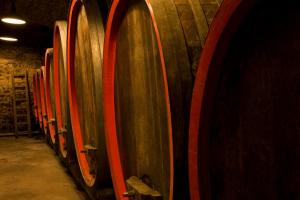 a row of wooden wine barrels in a cellar at Ferienwohnung, Weingut Trockene Schmitts in Randersacker +1 photo