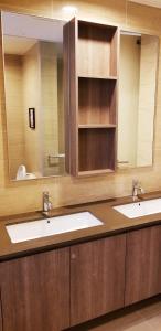 a bathroom with two sinks and a large mirror at By The Sea Beach Luxury Resort - Batu Ferringhi in Batu Ferringhi