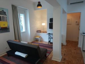 ein Wohnzimmer mit einem Sofa und einem TV in der Unterkunft Alex Home in Lissabon