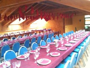 uma mesa longa com pratos e copos e cadeiras azuis em Casa de Montaña Alto Curueño em Lugueros