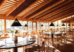 a restaurant with tables and chairs and windows at Konventum Conference Center in Helsingør