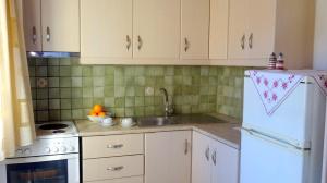 a kitchen with a sink and a white refrigerator at ARETOUSA in Agia Pelagia Kythira