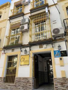 un edificio con ventanas de oro y una puerta en Giraldilla en Sevilla