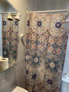 uma casa de banho com uma cortina de chuveiro e um WC em Giraldilla em Sevilha