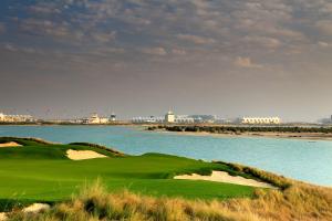 a golf course next to a body of water at Yas Island Rotana Abu Dhabi in Abu Dhabi