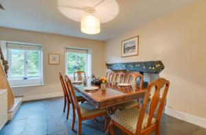 a dining room with a table and chairs and a fireplace at 2 Tan-y-castell in Dolwyddelan