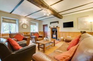 a living room with leather couches and a tv at 2 Tan-y-castell in Dolwyddelan