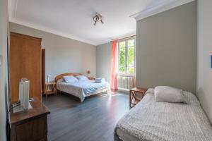 a bedroom with two beds and a tv in it at Hôtel du Rocher in Marseille