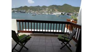 a balcony with two chairs and a view of a harbor at Simpson Bay Yatch Club 2 Bedrooms in Simpson Bay