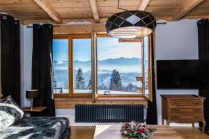a bedroom with a large window with a mountain view at udanypobyt Dom Hillside in Gliczarów