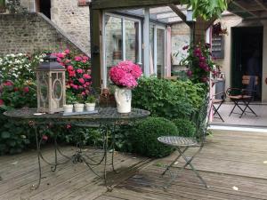 a table with flowers and a lantern on a patio at Chambres d'Hôtes Côté Campagne in Vaux-sur-Aure +6 photos