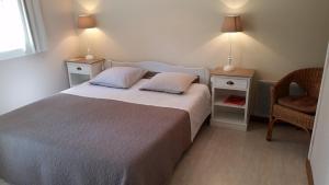 a bedroom with a bed with two night stands and a chair at Chambres d'Hôtes Côté Campagne in Vaux-sur-Aure