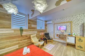 um quarto com uma cama, uma cadeira e uma televisão em Fox Rooms Aparthotel em Stara Zagora