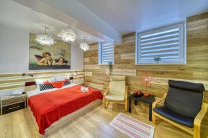 旧扎戈拉Fox Rooms Aparthotel的一间卧室配有红色的床和两把椅子