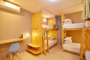 Pokój z 3 łóżkami piętrowymi i krzesłem w obiekcie Guilin Cyan Box Guest House w mieście Guilin