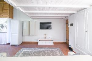 ein Wohnzimmer mit einem TV an einer weißen Wand in der Unterkunft San Niccolò Loft in Florenz