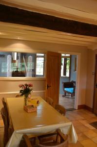 a dining room with a table with a vase of flowers on it at Bucket Lock Cottage in Warwick +20 photos