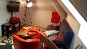 a living room with a couch and a table at Hôtel Restaurant L'Industrie in Saint-Omer