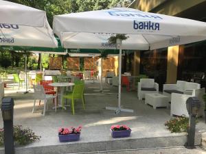 un patio con tavoli, sedie e ombrelloni di Hotel & SPA Otdih a Kavarna