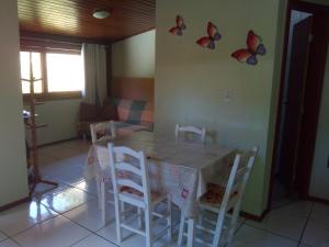 a kitchen with a table with chairs and butterflies on the wall at Casas na Praia de Bombas - Bombinhas in Bombinhas