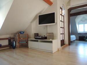 a living room with a flat screen tv on the wall at Stella's Attic Room in Toirano