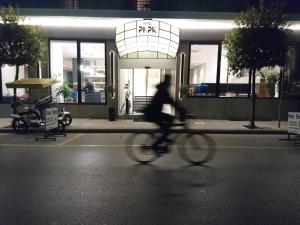 una persona montando una bicicleta delante de un edificio en Hotel Park, en Larisa